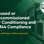 Unused or decommissioned air conditioning units on a commercial building with TM44 compliance warning text